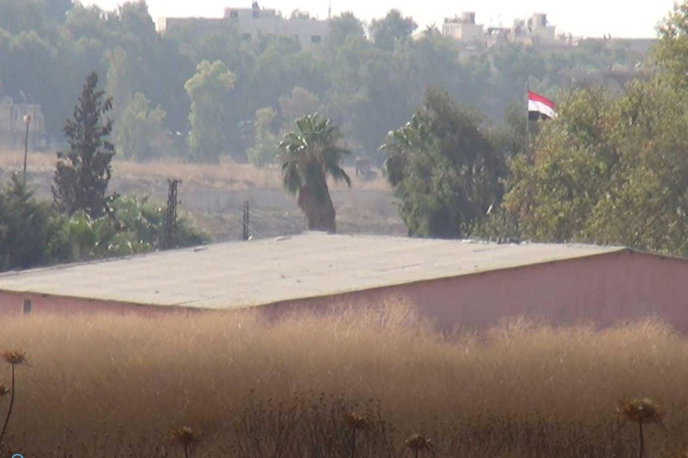 The Syrian regime troops hoist regime flag on public institutions in Qamişlo